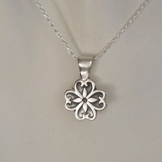 "This sweet sterling silver flower pendant has discreet heart shapes within each petal. It's small size makes it easily dressed up or down. Complimenting women and girls of all ages, this necklace would make a great \"first\" piece of fine jewelry or Sweet 16 gift. The sterling silver flower pendant comes on a hand cast sterling silver bale and an 18 inch sterling silver chain. **If you would like this pendant on a black leather cord, we would be happy to accommodate your request. Our standard m Wedding Sterling Silver Charm Necklace With Flower Charm, Sterling Silver Charm Necklace With Flower For Mother's Day, Mother's Day Sterling Silver Necklace With Flower Charm, Heart Pendant Jewelry With Flower Charm For Anniversary, Delicate Sterling Silver Heart Necklace For Anniversary, Anniversary Jewelry Heart Pendant With Flower Charm, Anniversary Heart Pendant Jewelry With Flower Charm, Sterling Silver Charm Necklace With Flower Pendant, Sterling Silver Charm Necklaces With Flower Pendant