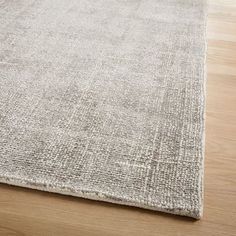 an area rug with wooden flooring on the side and light colored wood in the background