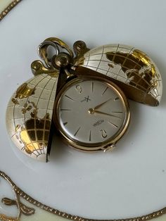 Featured here is a MANDANA XTensa Globe designed encased pocketwatch. It is designed in a gorgeous two toned gold/silver design. This is a 1930-40s pocketwatch with a Manuel wind up feature that is still functional and keeps time. This vintage pocketwatch is in very good, once loved condition.  Please view all photos for item details and sizing. All ~JewelsLilyCache~ items are delivered in a silver foiled, cotton filled gift box and safely shipped in a  waterproof bubble envelope.  Thank you for Timeless Gold Watch Accessories As A Gift, Timeless Gift Jewelry And Watches With Chronometer, Gold Jewelry And Watches With Metal Dial As Gifts, Yellow Gold Jewelry For Gift, Vintage Yellow Gold Watch Accessories For Gift, Gold Watch Accessories Gift, Engraved Yellow Gold Watch Accessories For Gift, Gold Pocket Watch With Metal Dial As Gift, White Gold Chronometer Watch Accessories As Gift