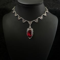 "This elegantly ornate necklace is made with antique silver tone centerpieces, featuring filigree and leaf details. Its mesmerizing design is accented with dazzling dark ruby red glass crystals with a large high quality faceted jewel hanging at its center.  Decorated portion is 8 1/2\" wide and 2 1/4\" tall in the very center.  Necklace length is adjustable with soldered stainless steel cable chain, lobster clasp and extender. If you would like a different length, please send us a message. If you don't see items with a color you want, feel free to ask about availability." Gothic Filigree Wedding Necklace, Gothic Filigree Necklace For Wedding, Gothic Wedding Necklace With Filigree Detail, Red Metal Filigree Jewelry, Red Gothic Necklace For Formal Occasions, Gothic Wedding Necklaces With Jewels, Ornate Red Wedding Necklaces, Formal Red Bridal Necklace With Intricate Design, Antique Red Necklace For Wedding