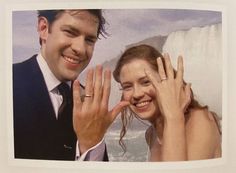 a man and woman posing for a picture with their hands up in front of them