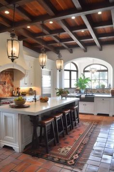 a large kitchen with an island in the middle and lots of lights hanging from the ceiling