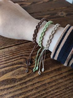 a person's arm with three bracelets on it, one is green and the other is brown