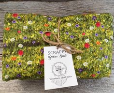 a green cloth with flowers on it and a tag that says scrappy grown sale