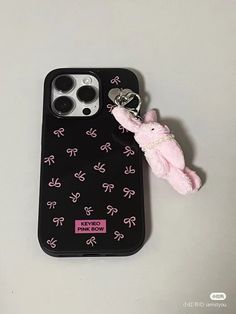 an iphone case with a pink bunny keychain attached to it