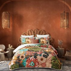 a bed in a room with orange walls and flowers on the comforter, along with wicker lamps