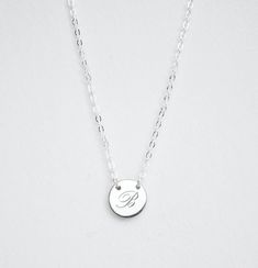 INITIAL NECKLACEThis beautiful minimalist initial or letter pendant necklace is perfect for everyday wear. It would make the perfect gift for a friend, mom, bridesmaid, or any loved one! The small round disk is held in place on the chainIf you want a layered look, click here to view the second necklace shown on our model - our 16mm size.DESCRIPTION• Material: High quality solid 925 sterling silver• Dimensions: 9mm disc• Finish: Sterling Silver ∙ 18K Gold ∙ Rose Gold• All our jewelry is custom an Silver Minimalist Initial Necklace With Delicate Chain, Classic Silver Initial Necklace With Delicate Chain, Simple Charm Necklaces For Mother's Day, Silver Minimalist Personalized Initial Necklace, Minimalist Silver Initial Pendant Necklace, Silver Minimalist Initial Necklace, Minimalist Silver Initial Necklace, Minimalist Silver Monogram Necklace, Simple Silver Necklaces For Mother's Day