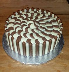 a cake with white and brown icing sitting on top of a wooden table