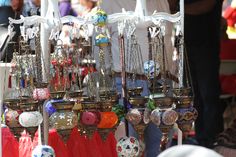 an outdoor market with lots of hanging ornaments