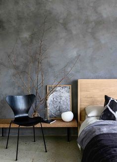 a bedroom with grey walls and black furniture