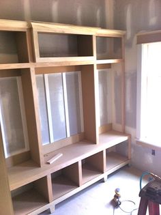 an empty room with shelves and tools in it, being worked on by a worker