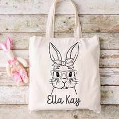 "Easter is on its way! A fun alternative to the traditional Easter basket are these adorable, personalized canvas totes. Perfectly sized for your littles one - not too big or bulky, but roomy enough for plenty of eggs and goodies!  * Sublimated in-house in our shop in Louisiana * Cotton/linen tote bag * Enter personalization in provided space * 12\" wide X 14\" tall * Ready to ship or pickup in 1-2 business days" Cute Rectangular Canvas Bag For School, Cute Canvas School Bag, Cute Canvas Bag For Back To School, Playful Bag Gift For Back To School, Playful Bags For Back To School Gift, Cute Rectangular Canvas Bags, Cute Cotton Bags For Back To School, Fun Cotton School Bags, Playful Cotton School Bags