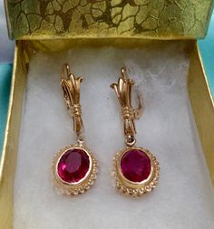 This is  gorgeous pair of oval faceted ruby earrings. Set in beautifully detailed heavily plated 14k gold over sterling silver. For pierced ears, lever back hook style. Each oval lab created ruby measures 10mm x 8mm. Earrings measure 4 cm (1 1/2") from top to bottom. Vintage from the 1950's. Please see the fine detail of these beauties! Local jeweler estimated the value of these earrings to be approx $275.00. Lovely gift for that special lady with a July birthday! I ship promptly! Ornate Gemstone Earrings For Formal Occasions, Elegant Oval Clip-on Jewelry, Vintage Gold Gemstone Earrings, Victorian Oval Earrings For Anniversary, Victorian Jewelry With Oval Matching Earrings, Antique Oval Gemstone Earrings, Ornate Yellow Gold Oval Earrings, Collectible Classic Ruby Jewelry, Vintage Ruby Jewelry Hallmarked