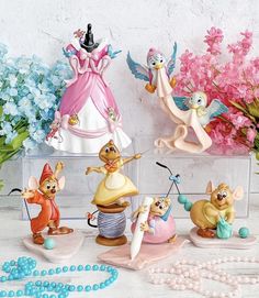 the figurines are on display in front of some flowers and other decorative items