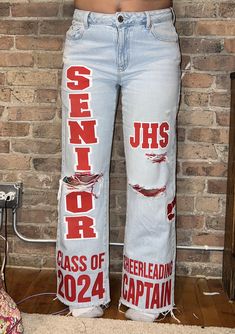 a person standing in front of a brick wall wearing jeans with the words class of 2012 written on them