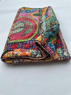 two pieces of colorful fabric folded on top of each other, one with an intricate design