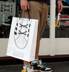 a skateboarder carrying a shopping bag and shoes in front of a store window