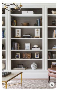 a living room filled with lots of white bookshelves