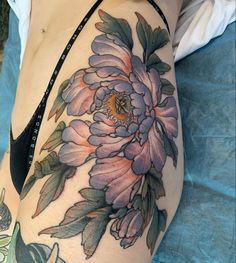 a close up of a woman's thigh with flowers on it