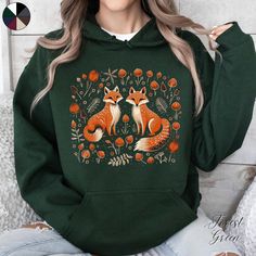 Forest Foxes Unisex Front Graphic Hoodie | Cottagecore Pullover Hoodie | Animal Lover Hoodie | Boho Clothes ✔️ Design on front only ✔️ Soft, warm and cosy heavy blend unisex hoodie  ✔️ Classic Fit ✔️ Fiber composition: 50% Cotton, 50% Polyester ✔️ Medium-heavy fabric (8.0 oz/yd² (271 g/m   ✔️ Spacious kangaroo pouch pocket  ✔️ Adjustable hood with self-coloured woven drawstring cord ✔️ No side seams ✔️ Tear away label ✔️ Made using 100% ethically grown US cotton 📏 Runs true to size ✨ Care instr Winter Fleece Hoodie With Cartoon Print, Winter Hoodie With Cartoon Print In Fleece, Hooded Cartoon Print Tops For Winter, Hooded Graphic Print Sweater For Fall, Fall Hooded Sweater With Graphic Print, Fall Cartoon Print Hooded Hoodie, Fall Hoodie With Cartoon Print, Graphic Print Hoodie For Fall, Green Fleece Hooded Sweater