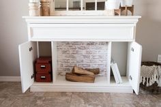 a white shelf with some books and other items on it in front of a brick wall