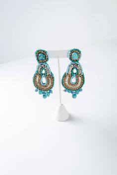 Drop earring hand-embellished with colorful crystals, various-sized resin beads. - Length: 3.8" - Width: 2" - Closure: Post back - Color: Turquoise - Style: #220309 Turquoise Drop Crystal Earrings For Party, Crystal Beaded Drop Earrings For Party, Elegant Multicolor Beaded Hoop Earrings, Elegant Multicolor Embellished Jewelry, Czech Glass Beaded Earrings With Dangling Beads, Crystal Beaded Earrings For Party, Turquoise Beaded Earrings For Party, Beaded Teardrop Jewelry For Party, Embellished Dangle Beaded Earrings For Party