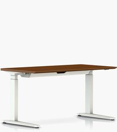 a wooden table sitting on top of a metal frame stand up desk with white legs