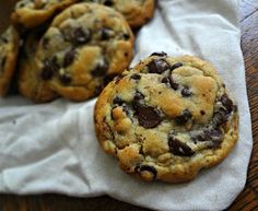 three chocolate chip cookies sitting on top of a white napkin