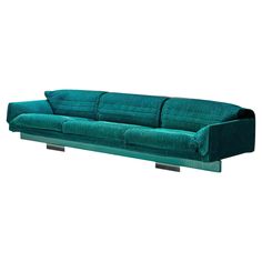 a green couch sitting on top of a metal stand