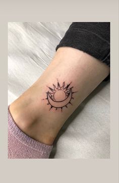 a woman's foot with a small sun tattoo on the left side of her leg