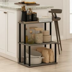 three tiered shelving unit with various items on it in a kitchen area next to an island