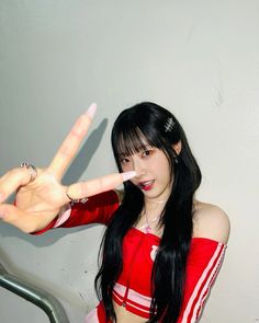 a woman with long black hair making the peace sign