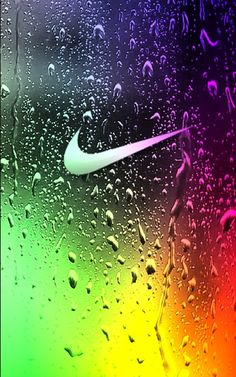 the nike logo is seen through raindrops on a rainbow colored glass wallpaper