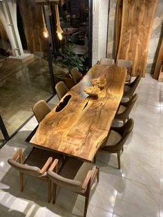 a large wooden table sitting in the middle of a room with many chairs around it