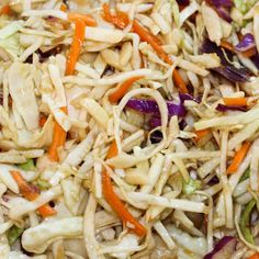 shredded carrots, cabbage, and other vegetables are mixed together in a salad dish