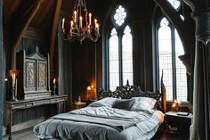 a large bed sitting in the middle of a bedroom next to two tall windows with chandeliers hanging from them