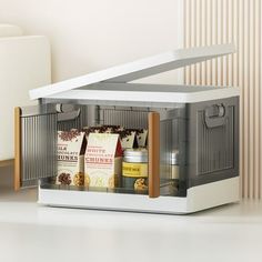 an open cabinet with spices and condiments in it on a table next to a white chair