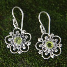 Peridot glows at the center of sterling silver blooms. Bali's Nyoman Rena crafts these stunning earrings by hand. Sterling silver & peridot Hook earrings Combination finish Handmade in & fairly traded from Indonesia Due to the handmade nature of this product, exact color and pattern of stone may vary. Sterling Silver Flower Earrings, Paw Print Jewelry, Ribbon Jewelry, Silver Flower Earrings, Blush Flowers, Printed Jewelry, Sterling Silver Flowers, Natural Gifts, Stunning Earrings