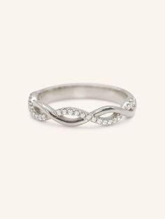 a white gold ring with diamonds in the middle and an intertwined design on top