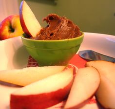 a bowl filled with chocolate ice cream next to sliced apples