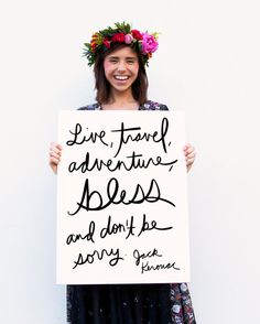 a woman holding up a sign that says live, travel, adventure, bliss and don't be sorry