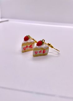 two pieces of cake with cherries on them sitting on top of a white surface