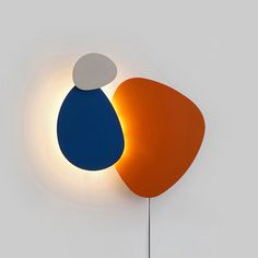 an orange and blue object is next to a white wall