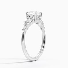 Cushion Cut Nadia Three Stone Engagement Engagement Ring - Platinum. This three stone ring features a dazzling cluster of round and marquise-shaped diamonds that rest upon the shoulders of the gently tapered band. The center gem is held by four claw prongs as it sits upon a slightly open gallery (2/5 total carat weight). Dazzling Marquise Cut Lab Grown Diamond Wedding Set, Dazzling Moissanite Marquise Cut Diamond Ring, Marquise Diamond Cluster Ring With Brilliant Cut, Marquise Cluster Ring With Brilliant Cut Diamonds, Dazzling Lab-grown Diamond Marquise Cut Wedding Ring, Marquise Moissanite Wedding Ring With Diamond Accents, Anniversary Marquise Lab Grown Diamond Ring, Anniversary Ring With Marquise Cut Lab Grown Diamond, Anniversary Marquise Cut Lab Grown Diamond Ring