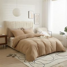 a bed in a bedroom with a beige comforter