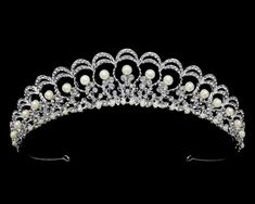 Pearl and Rhinestone Wedding Tiara This beautiful tiara will provide classic elegance to your bridal ensemble. The silver plated design is adorned with lustrous pearls and sparkling crystal rhinestones. This headpiece will be a memorable addition to your modern wedding look! Size: 1 1/4" High at its peak. Color: Silver/Light ivory. Style: T56300. Please allow about a week for delivery. Shipping Policy. Return Policy. Pearl Tiara, Bride Tiara, Beautiful Tiaras, Regal Design, Headpiece Jewelry, Rhinestone Tiara, Wedding Look, Light Ivory, Crystal Crown