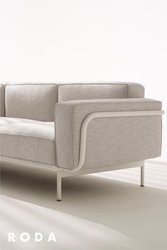 a white couch sitting on top of a floor next to a wall with the words roda above it