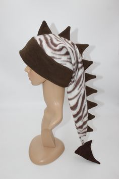 This listing is for the hat pictured, you will receive this exact hat.   With its eye-catching pattern and long row of spikes, everyone you encounter will wonder where you got such a great hat and will want one for themselves! Hat is sized to fit any ages from 4 years old and up- fits kids, adults, and teens alike. Extra stretchy, wonderfully warm band with ear flaps make this hat perfect for anyone! Feel free to ask for a custom sized hat, we will make one in any mix of colors/patterns, sized j Adjustable Warm Winter Costume Hats And Headpieces, Winter Novelty Adjustable Costume Hats, Novelty Adjustable Winter Hat, Winter Novelty Hats Adjustable, Adjustable Beanie Costume Hat For Winter, Adjustable Beanie For Winter, Dinosaur Tails, Dinosaur Hat, Silly Clothes