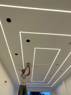 a man is painting the ceiling in an office