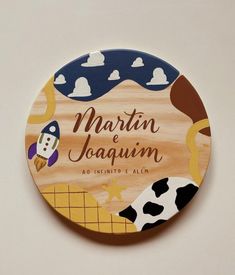 a wooden plate with an image of a cow and rocket ship on it, that says martin jaquinm